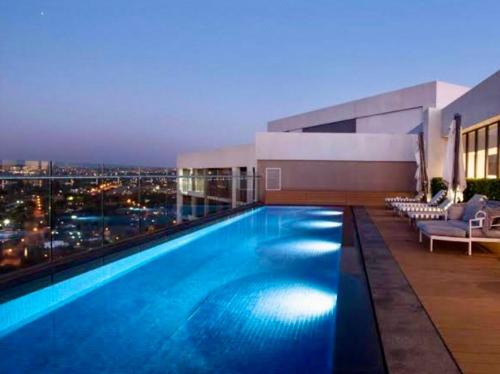 einem Pool auf einem Gebäude mit Skyline der Stadt in der Unterkunft Modern Studio in Menlyn Maine in Pretoria
