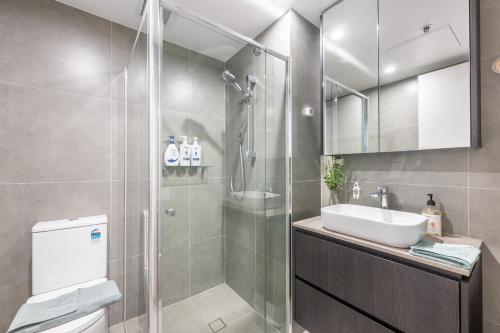 un bagno con doccia e lavandino di Central Comfort ,CBD 2BR w Free Parking, Wifi a Braddon