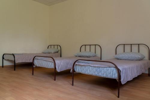 two beds are sitting in a room with a wooden floor at Sicheslav Hostel in Dnipro