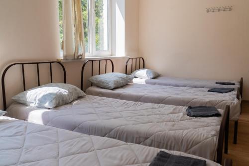 three beds sitting in a room with a window at Sicheslav Hostel in Dnipro