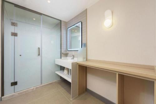 a bathroom with a sink and a shower and a mirror at Jinjiang Inn - Xishan Road in Dalian