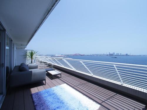 a balcony with a couch and a view of the water at Kobe Meriken Park Oriental Hotel in Kobe