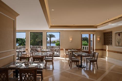 a restaurant with tables and chairs and windows at Iberotel Luxor in Luxor