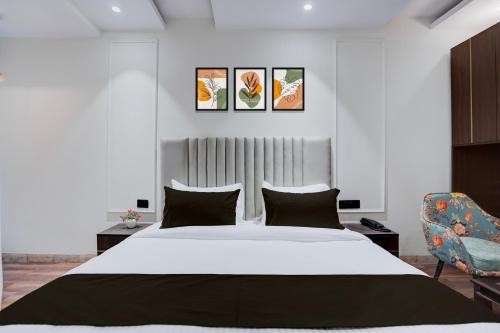 a bedroom with a large white bed and a chair at Super Townhouse Karol Bagh Formerly Hotel Unistar in New Delhi