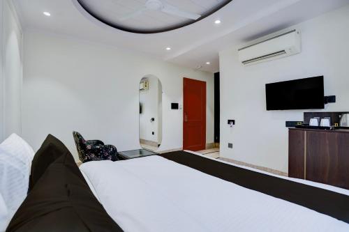 a hotel room with a bed and a flat screen tv at Super Townhouse Karol Bagh Formerly Hotel Unistar in New Delhi