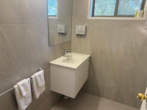 a bathroom with a white sink and a mirror at Yass Motel in Yass