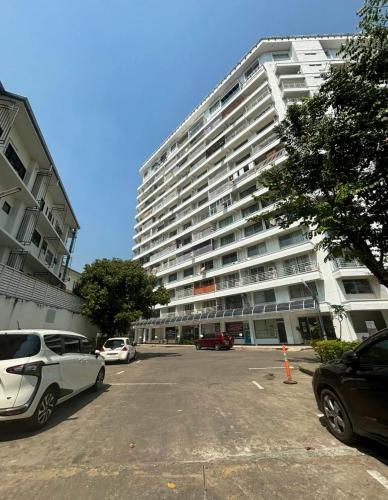 a large building with cars parked in a parking lot at Chomdoi Condominium in Chiang Mai