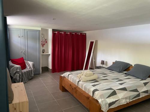 une chambre avec un grand lit avec un rideau rouge dans l'établissement La Villa Milo - Maison de vacances 6personnes #Clim #Piscine #CitéeMédiévale, à Vézénobres