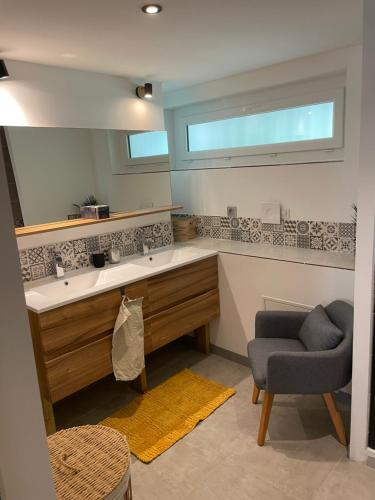 La salle de bains est pourvue d'un lavabo, d'une chaise et d'un miroir. dans l'établissement La Villa Milo - Maison de vacances 6personnes #Clim #Piscine #CitéeMédiévale, à Vézénobres