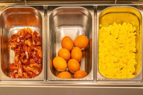 a container of food with eggs and other ingredients at Madi city Hotel in LʼAquila