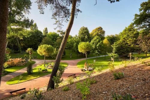 a park with benches and trees and a path at Villa Angelina La Baule in La Baule