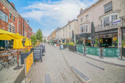 a city street with tables and umbrellas and buildings at The Oxford Rooms in Southampton