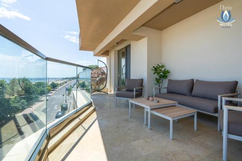a living room with a couch and a table on a balcony at Daria Boutique Hotel in Eforie Sud