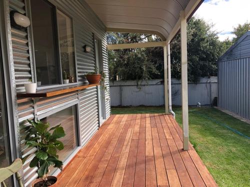 a porch with a wooden deck on the side of a house at Tea Tree Cottage - Heart of Port Elliot in Port Elliot