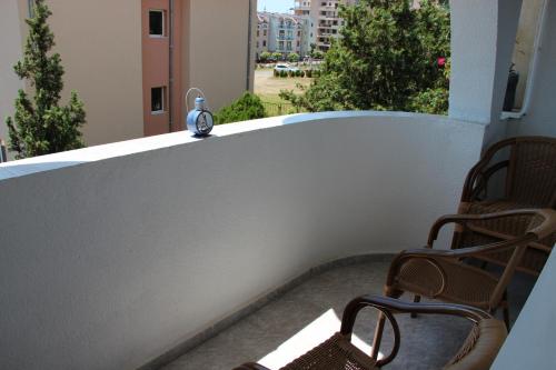 un orologio appoggiato sul davanzale di un balcone di Karchevi Apartment a Sveti Vlas
