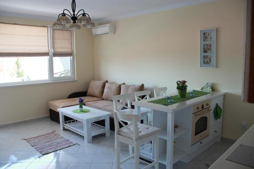 sala de estar con sofá, mesa y sillas en Karchevi Apartment en Sveti Vlas