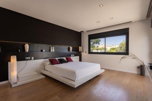 a bedroom with a white bed and a window at Casa Joan Only Familes con Piscina Privada in Llubí