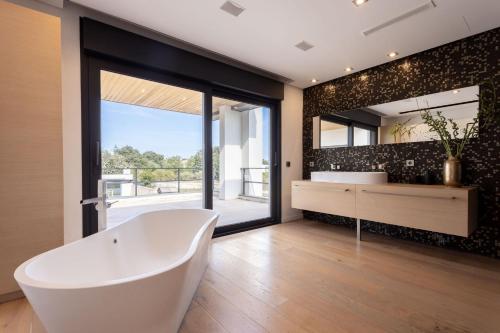 a large bathroom with a tub and a large mirror at Casa Joan Only Familes con Piscina Privada in Llubí