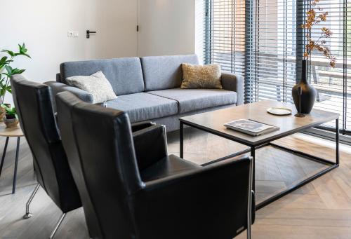 a living room with a couch and a table at Xl Newly Built Nature Villa, Wifi in Ledeacker