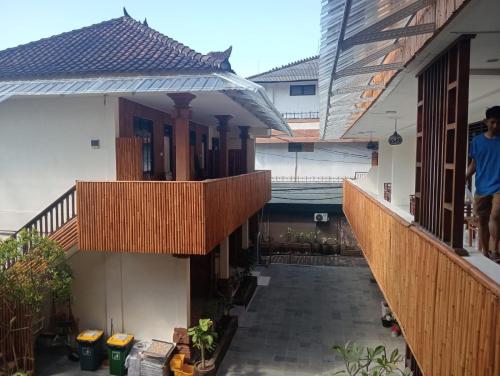 an empty courtyard of a house with wooden balconies at City Garden Bali Dwipa Hotel, Kuta in Kuta