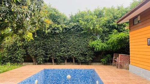a pool in the middle of a yard with trees at The galilee farmhouse in Noida