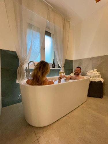 a man and woman in a bath tub in a bathroom at LI BRE Aosta Charme Apartment in Aosta
