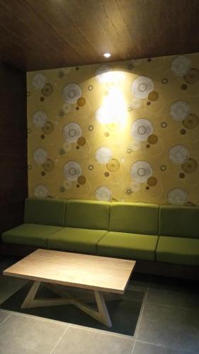 a green couch and a table in a room at Sweet Garden Guest House in Malang