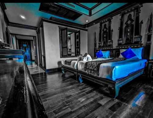 a bedroom with a large bed with blue pillows at Le Ayodhaya Palace Krabi Beach Resort in Krabi town