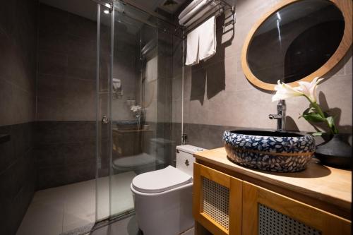 a bathroom with a toilet and a sink and a mirror at La ALBA Beach Villa in Hoi An