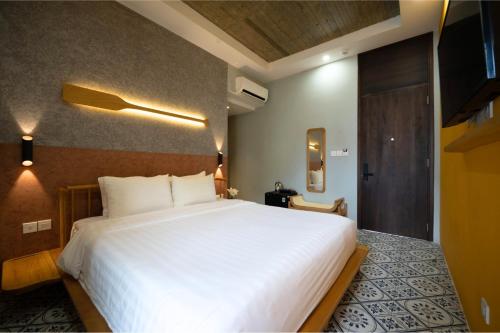 a bedroom with a large white bed in a room at La ALBA Beach Villa in Hoi An