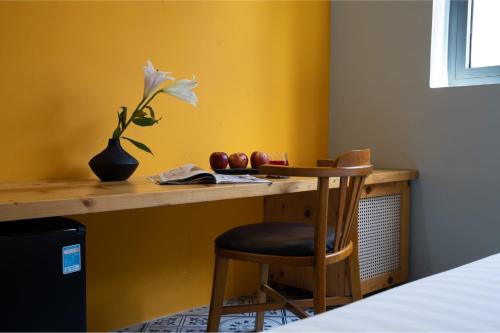 a room with a desk with a flower and a chair at La ALBA Beach Villa in Hoi An