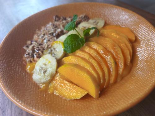 a plate of food with fruit on a table at Yulia Village Inn Ubud in Ubud