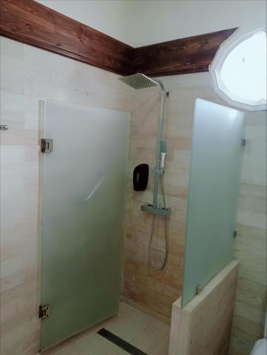 a shower with a glass door in a bathroom at El Patio Courtyard House in Tunis
