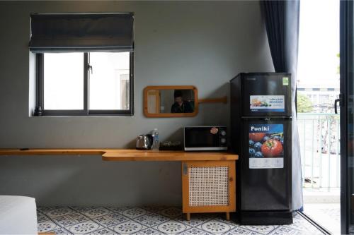 a room with a desk and a refrigerator next to a window at La ALBA Beach Villa in Hoi An
