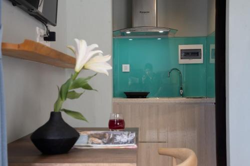 a flower in a vase on a table in a kitchen at La ALBA Beach Villa in Hoi An