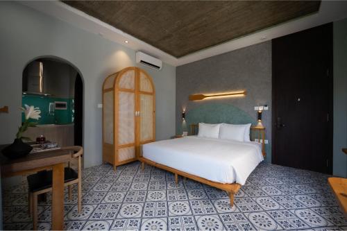 a bedroom with a large white bed and a desk at La ALBA Beach Villa in Hoi An