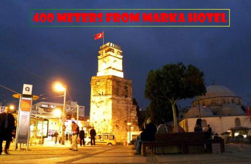 a clock tower with a flag on top of it at night at Marka Hotel in Antalya