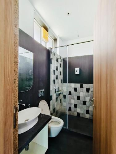 a bathroom with two sinks and a toilet and a shower at Ivy House in Khanivde