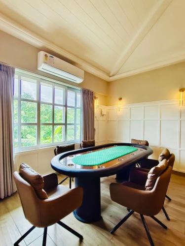 a pool table in a room with two chairs and a table at Ivy House in Khanivde