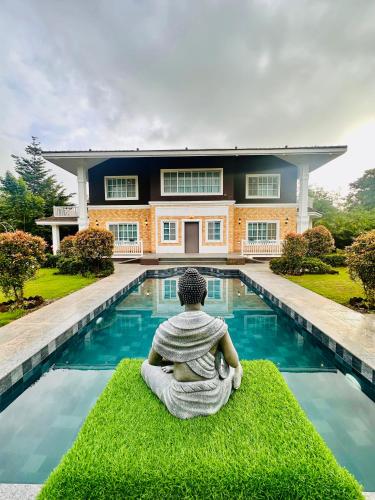 a statue of a person sitting in front of a house at Ivy House in Khanivde