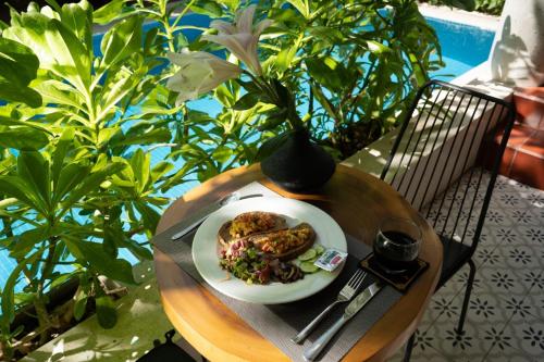 a plate of food on a table with a vase at La ALBA Beach Villa in Hoi An