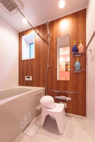 a bathroom with a tub and a toilet and a mirror at Stay&resort Luce ルーチェ in Urayasu