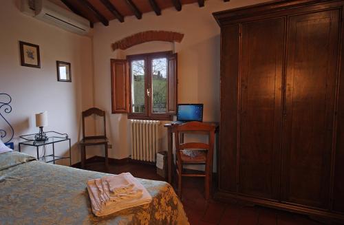 a bedroom with a bed and a dresser and a desk at Tenuta Il Burchio in Incisa in Valdarno