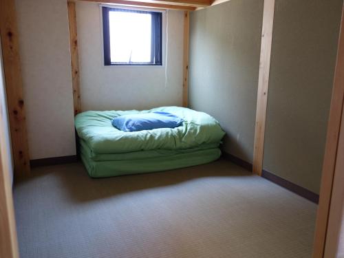 Habitación pequeña con cama en la esquina en Guesthouse WIND VILLA Kyoto, en Kioto