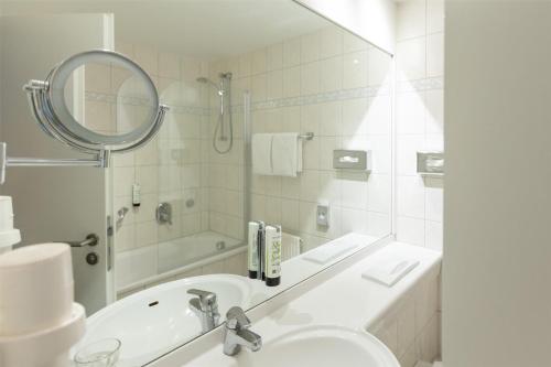 a white bathroom with a sink and a mirror at Best Western Plus Theodor Storm Hotel in Husum