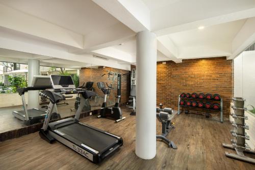 a gym with cardio equipment and a brick wall at The Akmani Legian in Legian