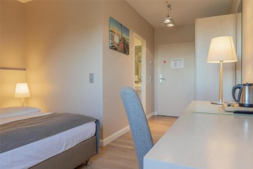a bedroom with a bed and a desk and a table at Best Western Plus Theodor Storm Hotel in Husum