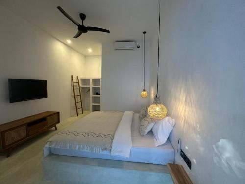 Un dormitorio con una cama y un ventilador de techo. en Radin Group 6, en Kuta Lombok