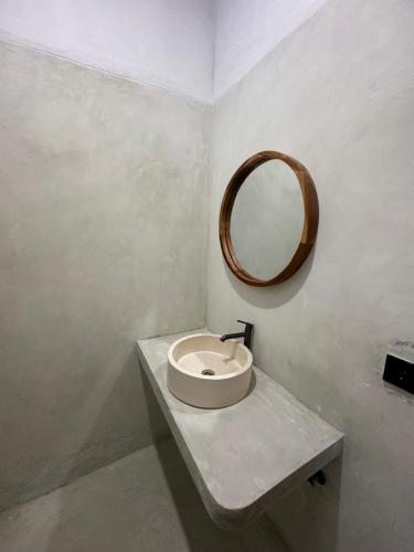 Un baño con un lavabo y un espejo en la pared. en Radin Group 6, en Kuta Lombok
