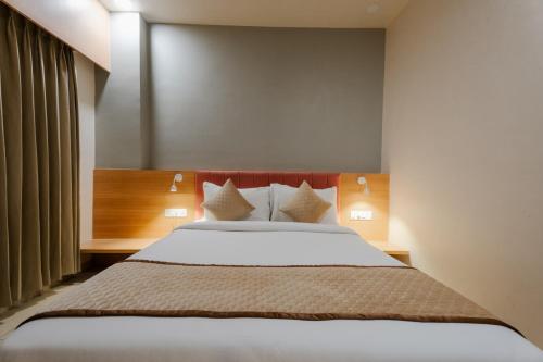 a bedroom with a large bed with white sheets and pillows at Prarambh By Siara in Nadiad